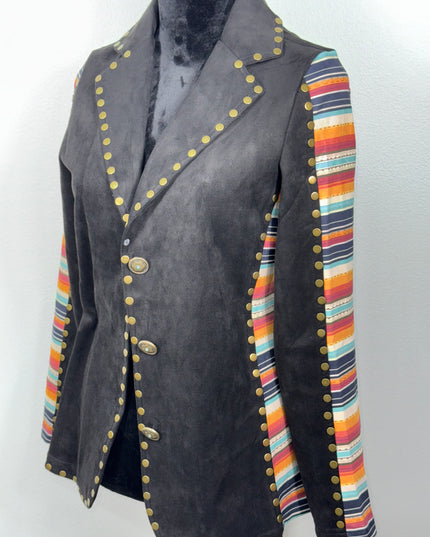 Black fabric with colorful striped border and gold- brass toned buttons on a soft fabric background